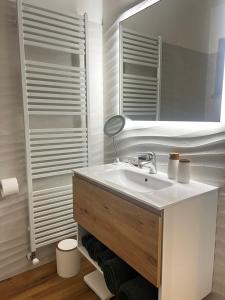 a white bathroom with a sink and a mirror at Casa Primavera in Agordo +5 photos