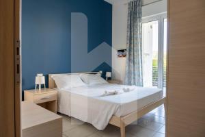 a bedroom with a large bed with a blue wall at Homiday - Appartamenti I Gabbiani in Pineto +60 photos