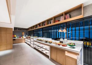 a large kitchen with a long counter with food on it at Manxin Hotel Beijing Lama Temple in Beijing
