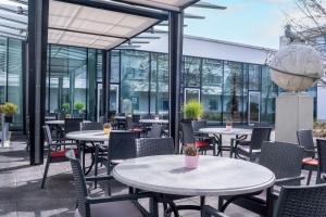 a patio with tables and chairs and windows at IntercityHotel Frankfurt Airport Terminal 3 in Frankfurt