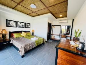 a bedroom with a green bed and a wooden table at Sanctuary Homestay Battambang in Phumĭ Don Téav +53 photos