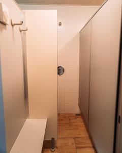 a shower stall in a bathroom with a wooden floor at SoulSafari aan Zee in Julianadorp