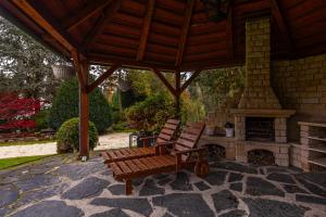 a wooden bench sitting under a pavilion with a fireplace at Villa Gineta in Štěchovice +40 photos