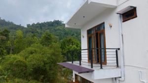 a balcony of a house with a view of the forest at Ella, Nine Arch Holiday Resort in Ella