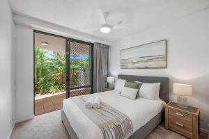 a bedroom with a large bed and a balcony at Pawfect Coastal - Pet friendly Beachfront Pool in Marcoola