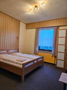 a bedroom with a large bed and a window at Moocks Hotel in Altenau