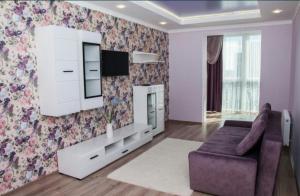 a living room with a couch and a tv at СУЧАСНА НОВА КВАРТИРА in Lutsk