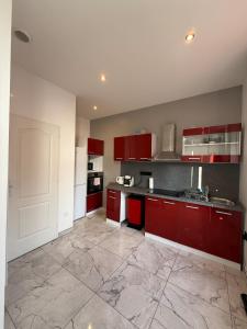 a kitchen with red cabinets and a large tile floor at Central Grenoble Lovely House in Grenoble