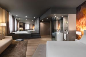 a bedroom with a large bathroom with two sinks and a tub at Hotel SB Ciutat Tarragona in Tarragona