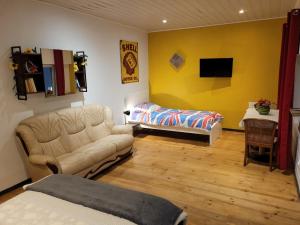 a living room with a couch and a table at Chambre liberté Domaine de la Belle Normandie in Condé-sur-Noireau
