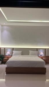 a bedroom with a large white bed with two lamps at Pondok Wahyu in Ubud