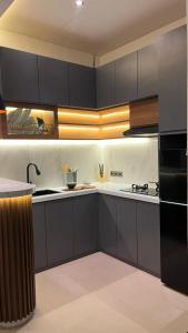 a kitchen with black cabinets and a black refrigerator at Pondok Wahyu in Ubud