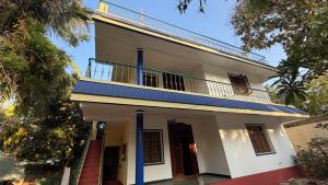 a white house with a balcony on top of it at Gravity Groups Blue Lagoon Villa in Kuilapayam