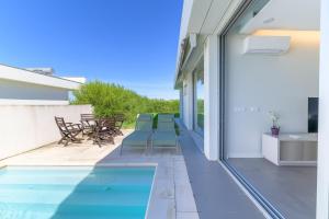 a patio with a swimming pool on a house at Vila Praia Grande in Sines
