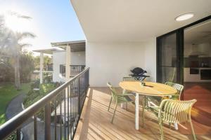 a patio with a table and chairs on a balcony at Coastal Drift - Beach Access Pool Spa Gym in Marcoola