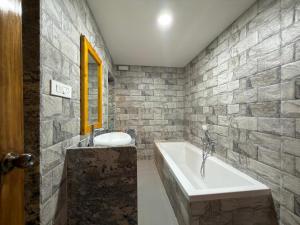 a bathroom with a bath tub and a sink at Marron Sea View Resort in Patnem +65 photos