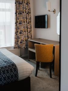 a hotel room with a desk and a bed at The Kilbirnie Hotel in Newquay
