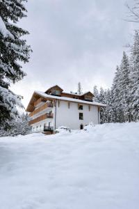 a house covered in snow with trees in the background at Berghotel Predigstuhl in Bad Goisern