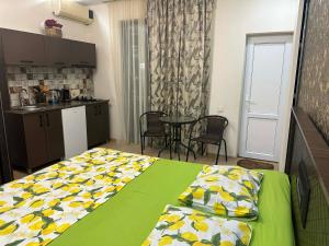 a bedroom with a bed and a kitchen with a table at cosy house in Kobuleti