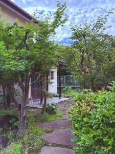 a garden path leading to a house at 伊東旅館 禅- Zen - in Ito