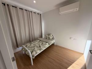 a small bed in a room with a window at Modern Karnup House in Karnup