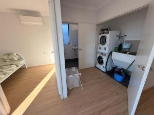 a small room with a sink and a washing machine at Modern Karnup House in Karnup