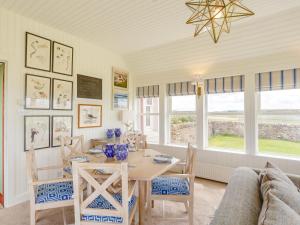 a dining room with a table and a couch at 3 Bed in Thurso oc-ca337 in Mey +14 photos