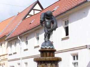 a statue of a girl on a fountain in front of a building at Ferienwohnungen Seewald in Teterow