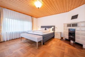 a bedroom with a bed and a wooden ceiling at Alpen Lodge Chiemgau in Schleching