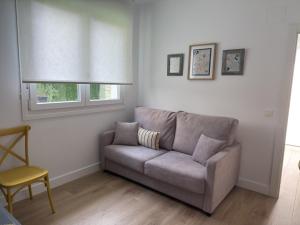 a living room with a couch and a window at Alojamientos Dima Costa in Laredo