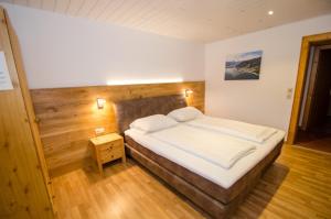 a bedroom with a large bed with white sheets at Appartementhaus LAKE VIEW by All in One Apartments in Zell am See