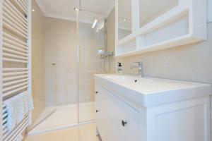 a white bathroom with a sink and a shower at Alpen Lodge Chiemgau in Schleching +13 photos