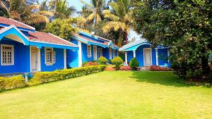 a blue house with a yard in front of it at SUSAGADE in Vagator