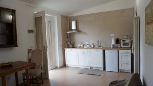 a kitchen with white cabinets and a sink and a table at La Casetta in Monteforte Irpino
