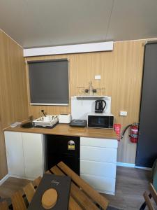 a kitchen with a sink and a microwave on a counter at The Secret Place by Tiny Away in Palmvale