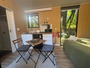 a kitchen with two chairs and a table and a bed at The Secret Place by Tiny Away in Palmvale