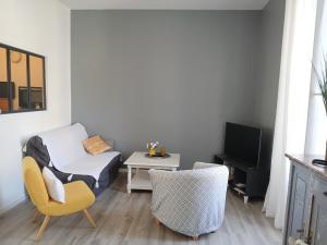 a living room with a bed and a chair and a table at Le 46 Clos Vert in Erquy