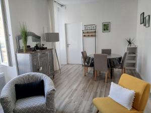 a living room with a table and chairs at Le 46 Clos Vert in Erquy