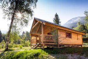 a log cabin in the woods with a porch at Huttopia Bozel en Vanoise in Bozel