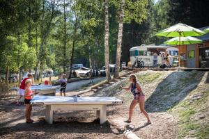 a woman and a child playing table tennis at a park at Huttopia Bozel en Vanoise in Bozel +12 photos