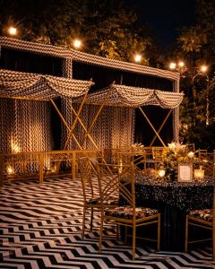 a patio with a table and chairs at night at Amantran Farm Retreat in Varanasi