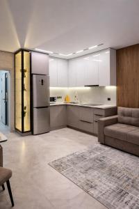 a large kitchen with a couch and a refrigerator at ЖК Альфараби in Kokshetau