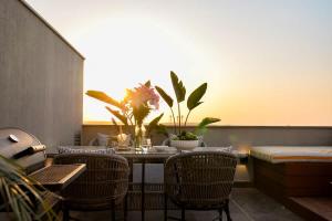 a dining room with chairs and a table with plants at VELORA - Sodic Penthouse with jacuzzi & big terrace over New Cairo view in New cairo