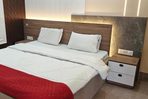 a bedroom with a large bed with a red blanket at Amantran Farm Retreat in Varanasi