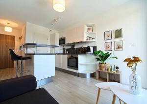 a kitchen and living room with white cabinets at L'Échappée Verte - T2 avec balcon in Saulx-les-Chartreux