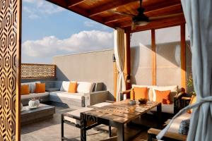 a patio with a couch and a table and chairs at VELORA Serviced Rooftop Studio With Private Jacuzzi in Sodic New cairo in New cairo