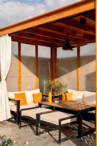 a patio with couches and a coffee table on a patio at VELORA Serviced Rooftop Studio With Private Jacuzzi in Sodic New cairo in New cairo