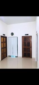 ein Zimmer mit zwei Holztüren und einer weißen Wand in der Unterkunft Im-Un in Ban To La Nua
