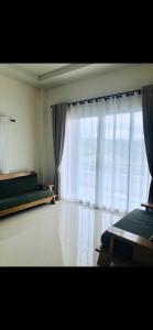 ein Schlafzimmer mit zwei Betten und einem großen Fenster in der Unterkunft Im-Un in Ban To La Nua