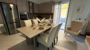 a kitchen with a table and chairs and a refrigerator at Eleni Apartment in Perdika